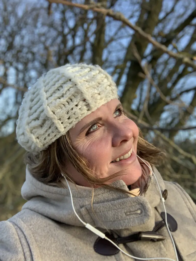 Portræt af Manja fra Hvisker med heste udendørs i naturen med hvid strikhue.