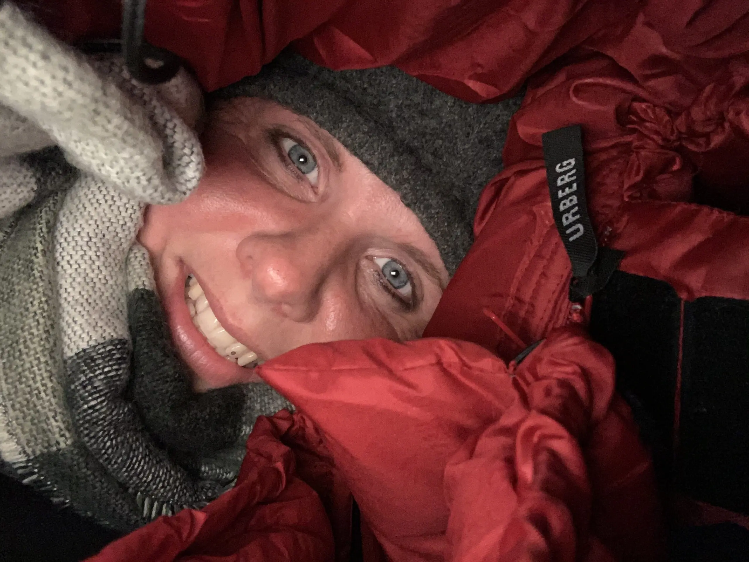 Manja fra Hvisker med heste smiler varmt indpakket i en sovepose udendørs.
